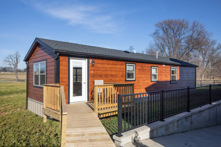 redwood lodge cabin by dwellity with brown siding and dark shingled roof