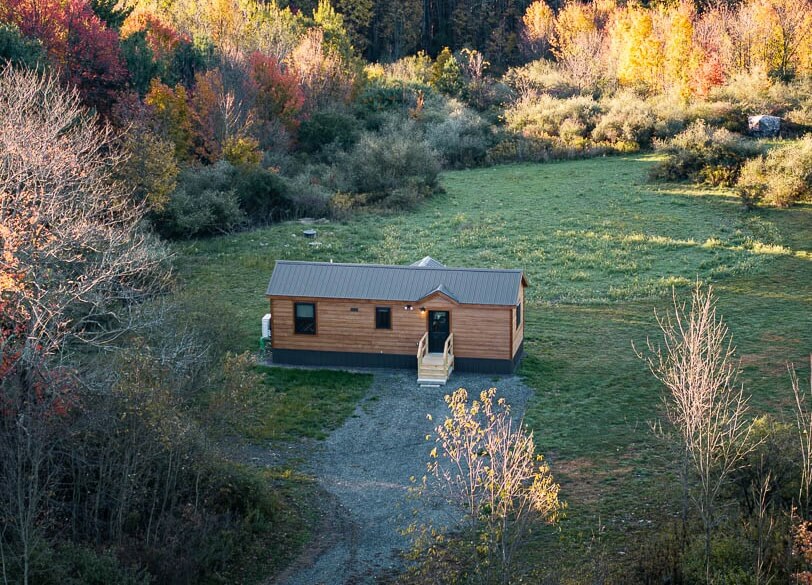 beaverdam cabin in grass yard in forest by dwellity