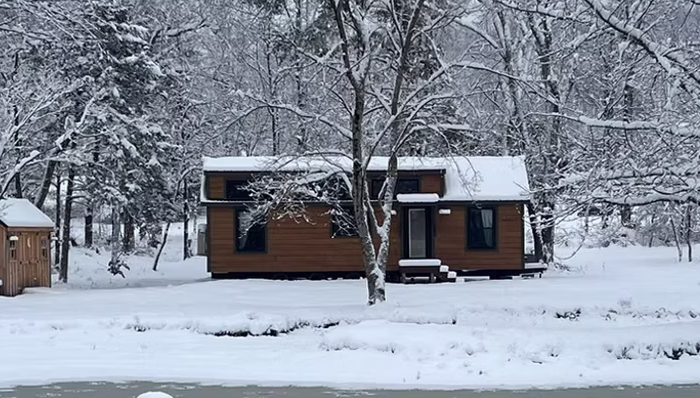 dwellity cabin in snow beside pond